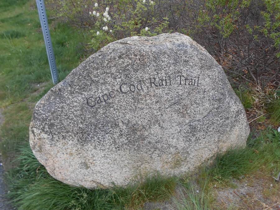 Cape Cod Rail Trail sign on rock